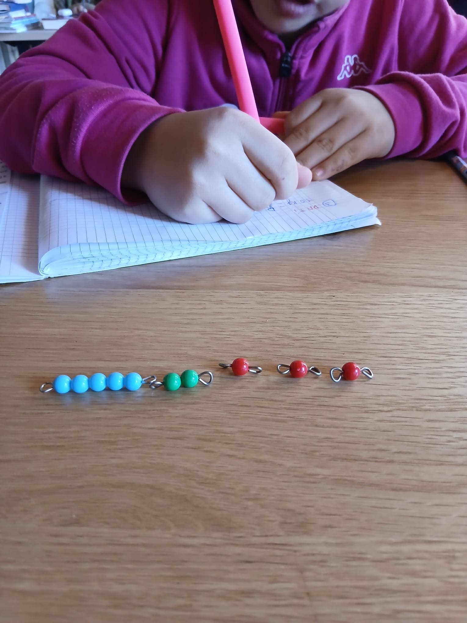 Bambina concentrata che svolge un'attività Montessori a tavolino